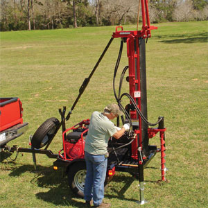 Big Beaver Drill Rig. Man drilling a hole with extendable augers with the Big Beaver Drill Rig.