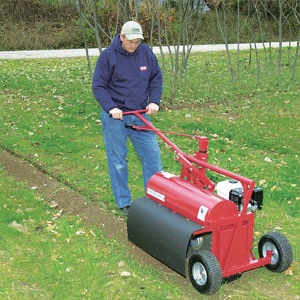 Kwik Trench Mini Trencher. Cutting a trench into the ground for irrigation with a mini trencher.